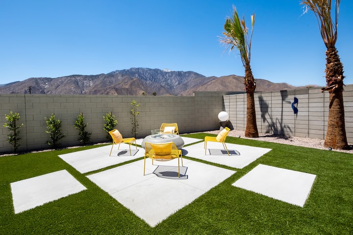 Fire pit with lounge chairs on the lawn, mountains behind