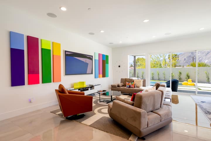 Open living room with colorful artwork and mountain views through the windows