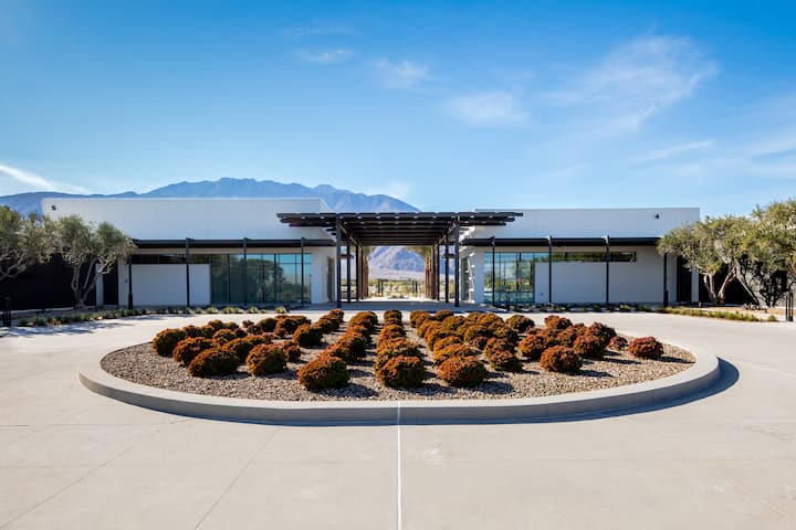 The Miralon clubhouse, a low modern building behind a circular planted courtyard