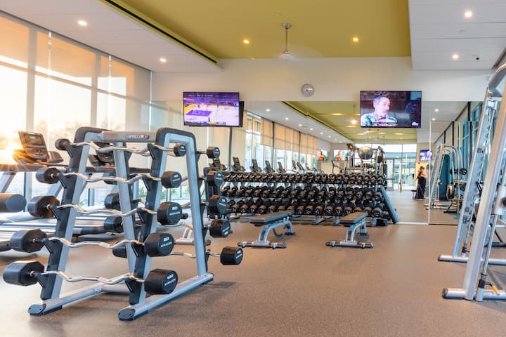 Racks of free weights and machines in the Miralon community gym