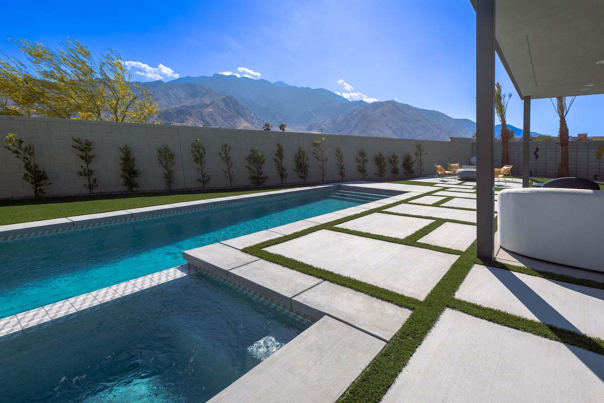 Private lap pool and lawn at Posh Place, with the San Jacinto Mountains beyond
