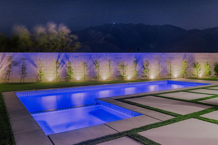 The pool and hot tub lit blue at dusk